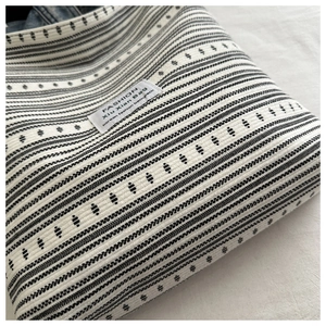 Gros plan d'un sac cabas tissé à rayures noires et blanches avec motifs géométriques