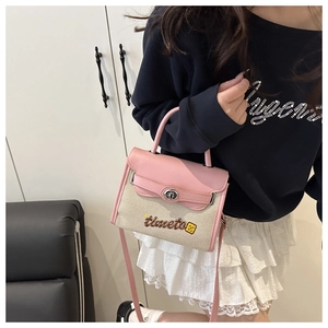 Detail of pink and beige canvas crossbody bag with cartoon embroidery and twist lock