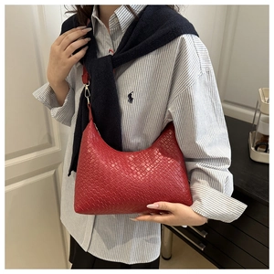Detail view of a red woven PU leather underarm bag shown in a professional model shot