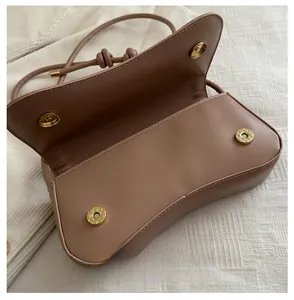 Detailed macro view of the interior magnetic gold snaps on a beige leather handbag