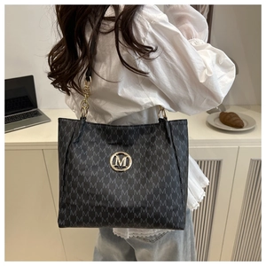 Detail view of stylish black tote bag with M-letter jacquard and chain strap for women