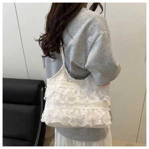 Detailed view of white multi-layer lace pleats on a stylish women's shoulder bag
