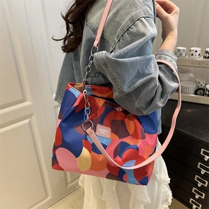 Fashionable contrast color tote bag with geometric patterns and chain strap detail
