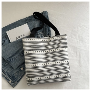 Détail de la texture tissée épaisse et du motif géométrique rayé sur un sac cabas