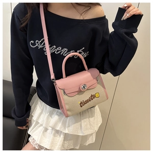 Detail of pink and beige canvas handbag with leather flap and timeto embroidery