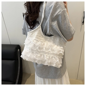 On-body view of a white tiered lace tote bag showing carrying length and casual style