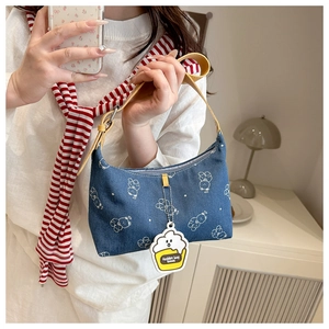 Detail of denim shoulder bag with bear patterns and bright yellow adjustable strap