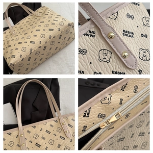 Detail view of lychee texture leather tote with bear patterns and gold hardware