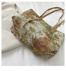 Detailed macro view of woven floral jacquard fabric and leather handles on tote bag