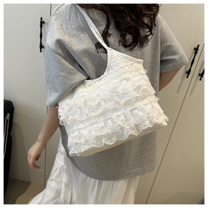 Detailed back view of a white multi-layered lace shoulder bag on a female model