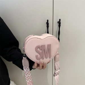 Pink heart-shaped crossbody bag with SM logo and wide woven strap for women