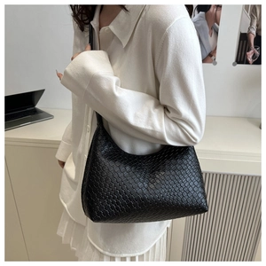 Detail view of black woven tote bag showing texture and stylish shoulder carry
