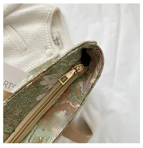 Detail of smooth gold metal zipper closure on a vintage tapestry oil painting tote bag