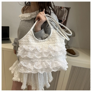 Detailed view of white lace tote bag with tiered ruffles and elegant mesh texture