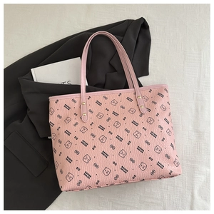 Detail of pink faux leather tote bag showing lychee grain texture and bear prints