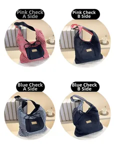 Detail of reversible tote bag showing plaid fabric and denim texture with front pocket