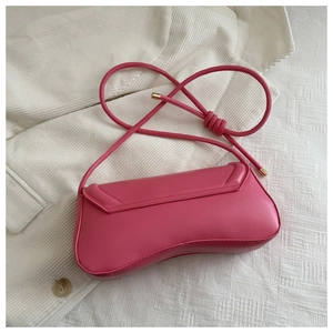 Detail view of the deep pink leather hobo bag showing its curved shape and gold metal accents