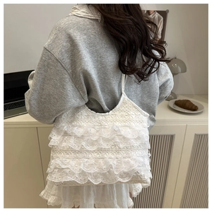 Detailed close-up of tiered white lace ruffles on a vintage style shoulder tote bag