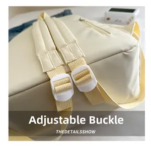 Close-up of the adjustable white plastic buckle and durable strap on a cream canvas backpack