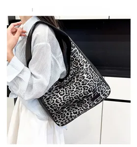Detail of high-capacity tote bag with black and white leopard print and leather straps