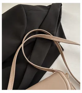 Detail view of the durable and comfortable shoulder strap of the beige saddle bag