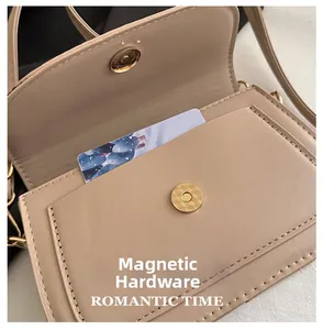 Gros plan du fermoir magnétique doré d'un sac besace minimaliste en similicuir beige