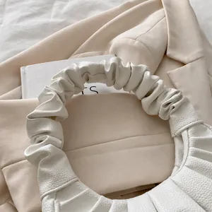 Détail du sac nuage blanc avec poignée froncée souple et cuir à texture litchi fin