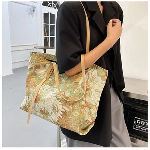 Detail of vintage floral jacquard tote bag with faux leather shoulder straps and rich texture