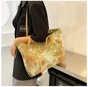 Detail view of large tote bag with daisy floral tapestry and yellow leather straps