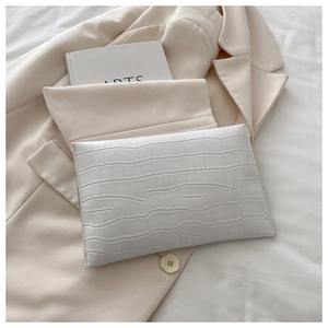 Detailed macro view of the white crocodile-embossed PU leather envelope clutch bag surface