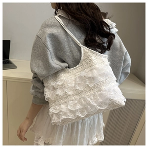 Close-up of white multi-layer lace shoulder bag with delicate ruffled fabric textures