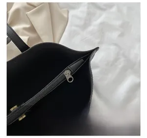 Detail view of the spacious black faux leather tote bag with a durable metal zipper