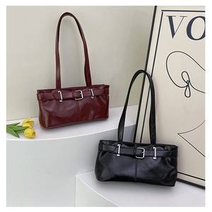Macro detail of dark red and black high-gloss PU shoulder bags with silver buckles