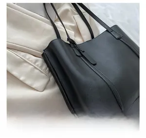 Detail of black leather tote bag showing parallel stitching on matte texture