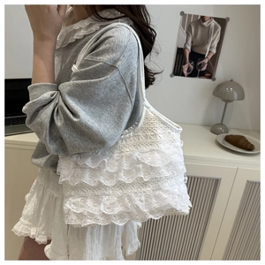 Detail of white lace ruffle shoulder bag showing layered texture and delicate patterns