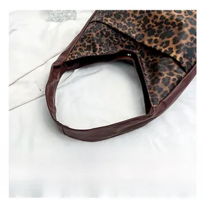 Detail view of leopard print shoulder bag featuring wide strap and magnetic closure