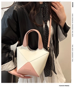 Détail d'un sac seau en similicuir patchwork rose et blanc avec bandoulière.