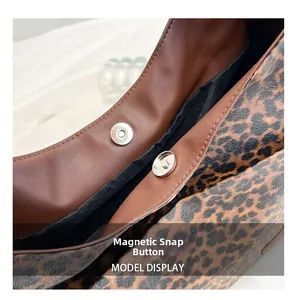 Close-up of secure magnetic snap button closure on leopard print shoulder bag