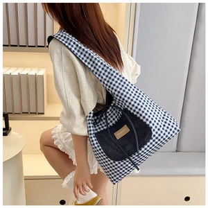 Blue plaid tote bag detail with denim pocket and fashion label on shoulder