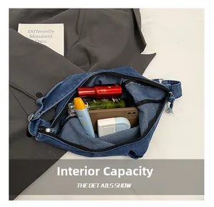 Detail showing internal capacity of blue denim bag with phone and cosmetics