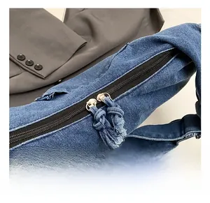 Detail of premium double-way metal zipper with denim tassels on a stylish navy bag