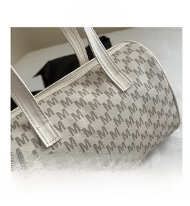 Dettaglio della borsa Boston con motivo monogramma M grigio e texture in pelle bianca