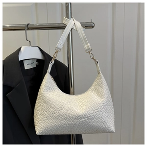 Detail of white woven textured hobo shoulder bag for commute hanging on a rack