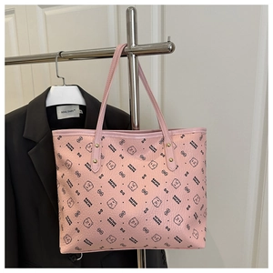 Close-up of pink tote bag with cartoon bear print and metallic rivet reinforced handles