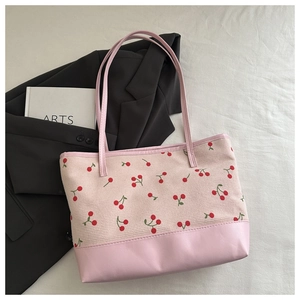 Detail of pink corduroy tote bag featuring red cherry embroidery and leather base