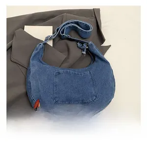Detail view of the washed denim hobo bag featuring a front pocket and soft texture