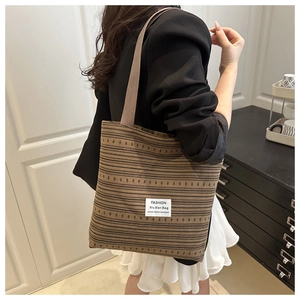 Vue détaillée du sac cabas en tissu rayé marron avec motif texturé et étiquette en tissu blanc
