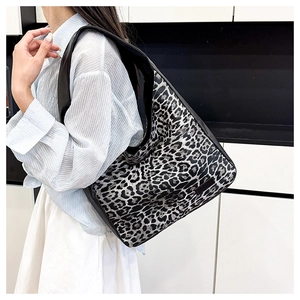 Detail of wide black shoulder strap and leopard print canvas on a large tote bag