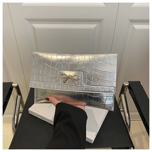 Close-up of silver stone pattern handbag with a golden bow metal buckle detail