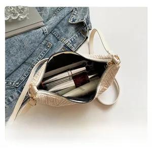 Interior view of straw crossbody bag showing storage capacity for phone and cosmetics